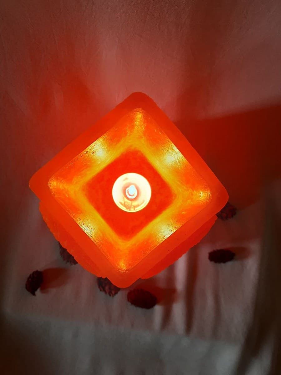 Buddha hurricane tealight holder glowing with a lit tealight, top view