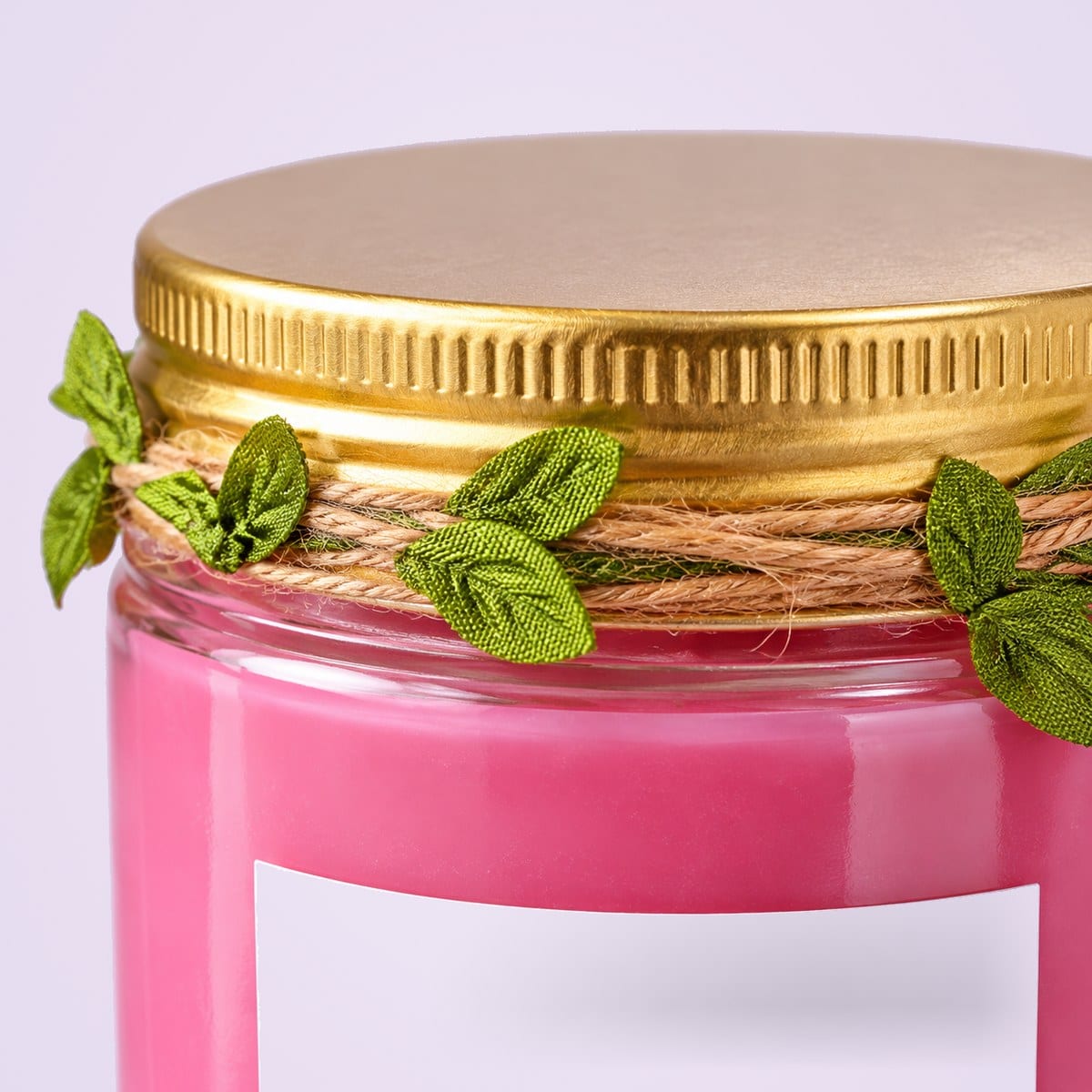 Close-up of the candle jar's gold lid and leaf trim