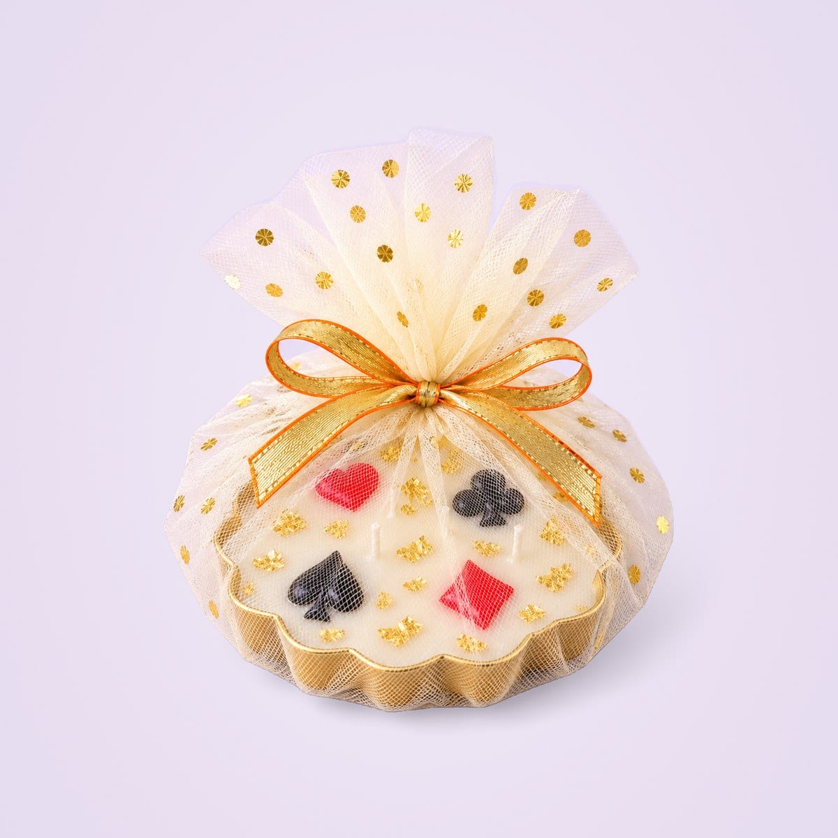 Card-suit urli candle wrapped in ivory tulle with gold dots and a gold and orange bow