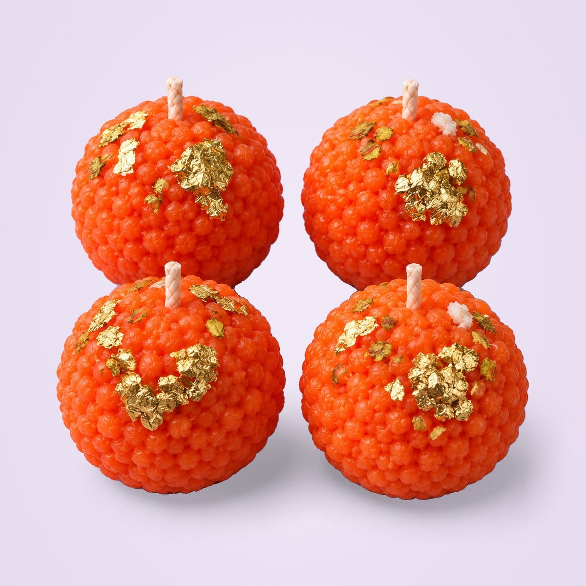 Four orange motichoor laddu candles