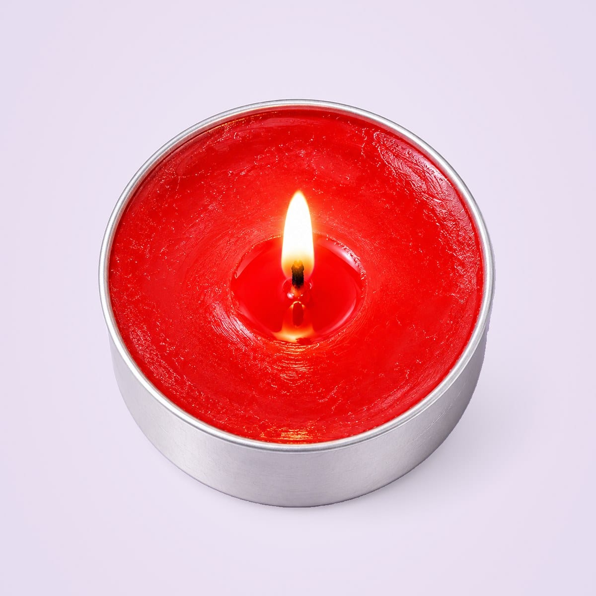 A lit red tealight in its metal cup