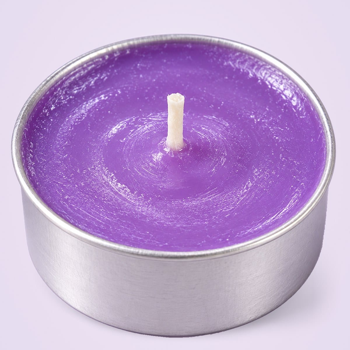 Close-up of a lavender tealight and its metal rim
