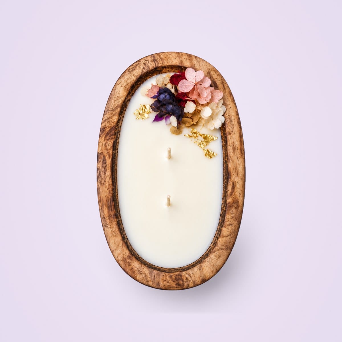 Wooden dough tub candle from above, with two wicks and dried flowers