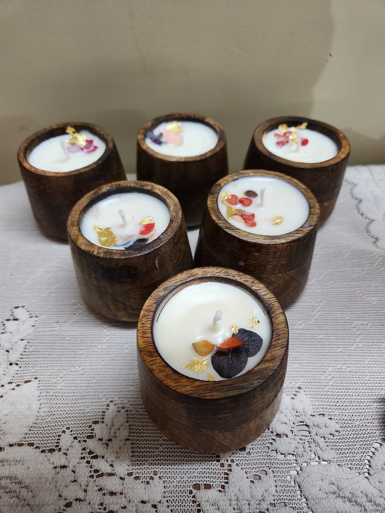 Group of wooden jar soy wax candles topped with dried petals