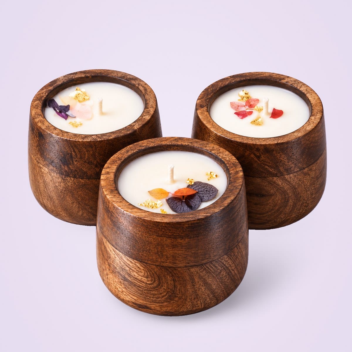 Three wooden jar candles with petal toppings